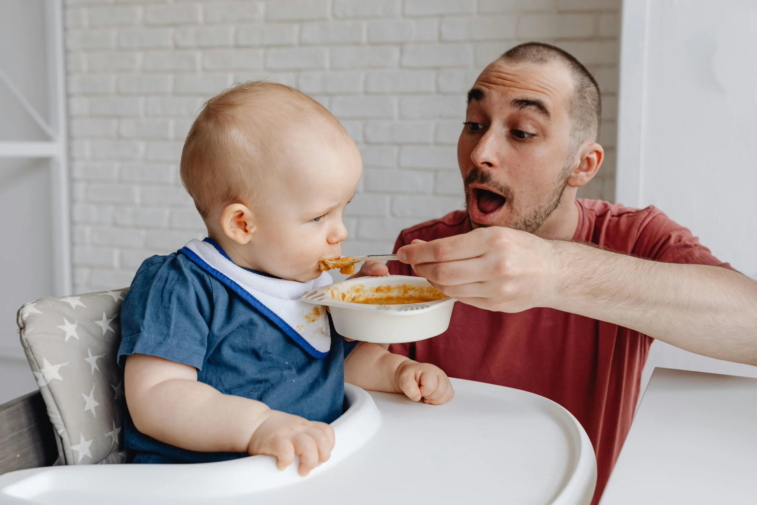 a father giving food to his baby during travel